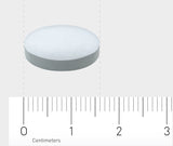 Das Bild zeigt eine weiße, runde Tablette, die auf einem Lineal mit Zentimeterangaben liegt. Die Tablette ist zentral im Bild platziert und das Lineal zeigt Maße bis zu 3 Zentimetern an. Der Hintergrund ist neutral grau.