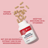 Ein weißes Fläschchen mit der Aufschrift 'Adapto B-Complex Dietary Supplement' liegt geöffnet auf einer rosa Fläche. Einige beige Kapseln sind aus der Flasche herausgefallen. Auf dem Bild sind Beschriftungen zu sehen: 'Vegane Kapseln', 'Kräftige Mischung an B-Vitaminen', 'Mit 200 mg Rhodiola-Extrakt und 50 mg Weißdornbeeren'.