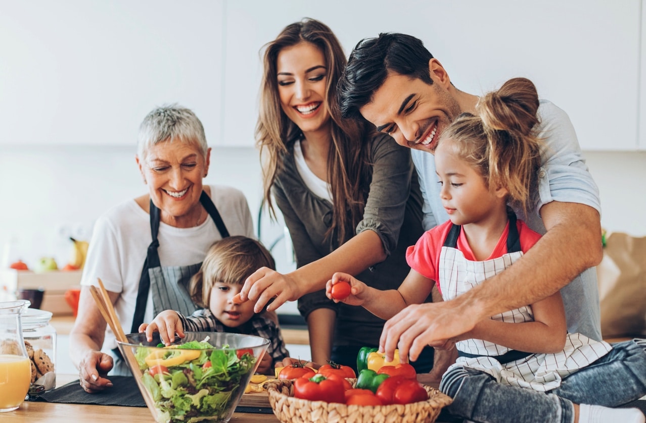 Familie beim Zubereiten eines Salates