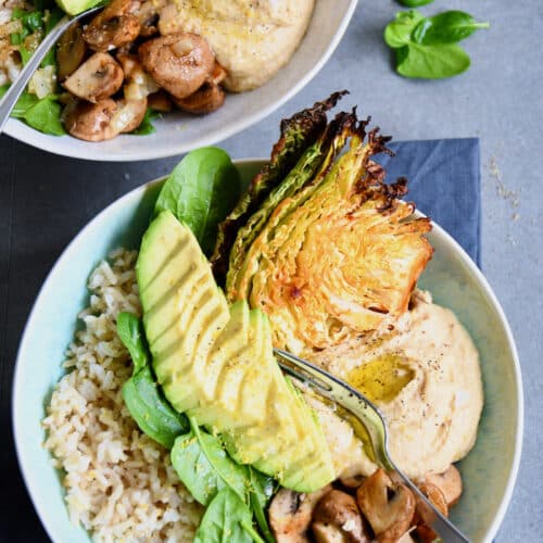 Bowl mit Vollkornreis, Wirsing, Spinat, Champignons, Humus und Avocado