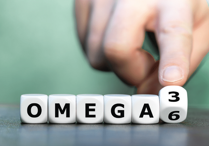 Eine Reihe von Würfeln, auf denen die Buchstaben O-M-E-G-A und die Ziffern 3 und 6 zu sehen sind.