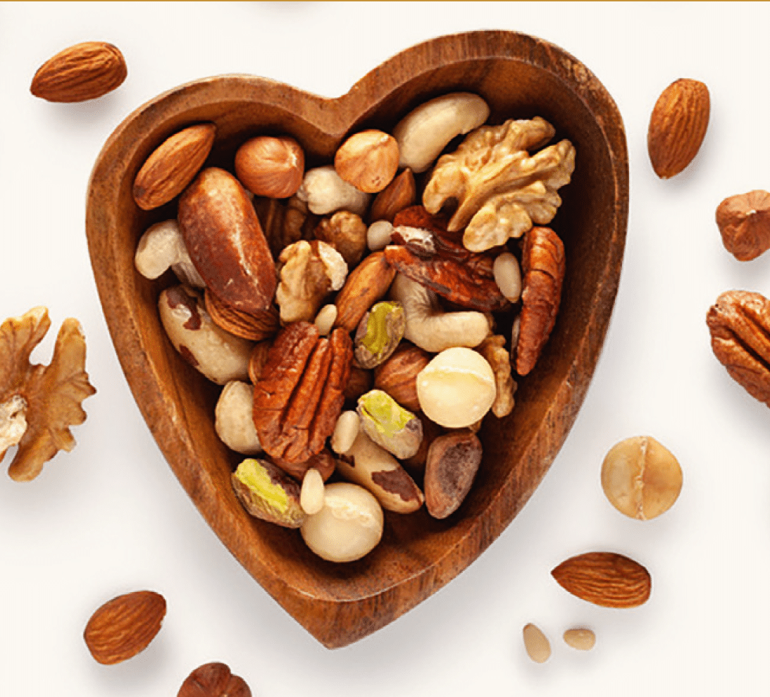 verschiedene Arten von Nüssen in einer herzförmigen Holzschale