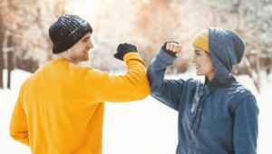 sportliches Paar bei Fitness-Übungen im Schnee