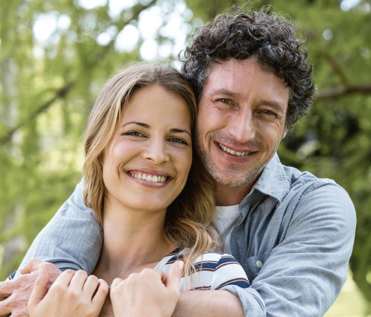 Ein glückliches junges Paar umarmt sich im Wald