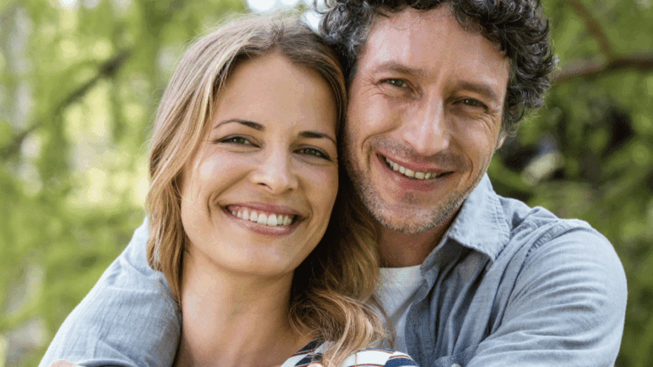 Ein glückliches junges Paar umarmt sich im Wald